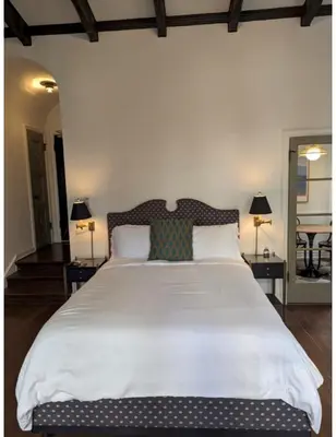 a large white bed in a bedroom with two lamps at Villa Carlotta - 30 Day Requirement in Los Angeles