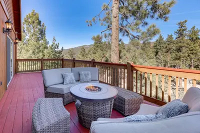 a patio with couches and a fire pit on a deck at Elegant Big Bear Cabin Half Mi to Big Bear Lake! in Big Bear Lake
