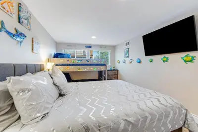 a bedroom with a bed and a flat screen tv at Surreal Feel Lakeview Chalet in Lake Arrowhead