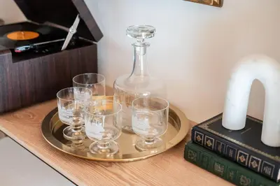 a tray with glasses on a table with a decanter at Wild Olive Lodge ° Serene grandma chíc getaway cabin in Running Springs