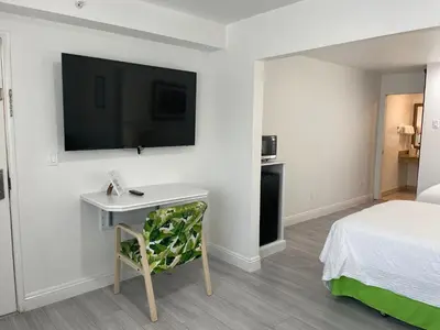 a hotel room with a bed and a desk and a tv at Loma Linda Inn in San Bernardino