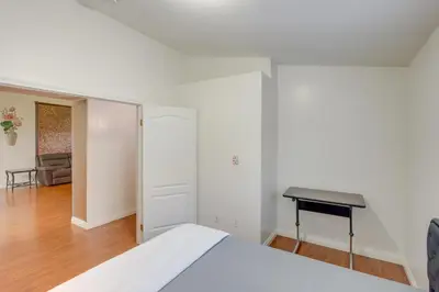 a white bedroom with a bed and a desk at Pet-Friendly California Retreat with Fenced-In Yard! in Bakersfield