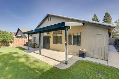 a house with a covered porch in a yard at Pet-Friendly California Retreat with Fenced-In Yard! in Bakersfield