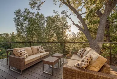 two couches and a table on a deck with a tree at Lake Front Modern Luxury in Lake Arrowhead