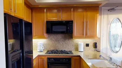 a kitchen with wooden cabinets and a stove top oven at 3 Bedroom 2 Bath Beachfront Home in Huntington Beach