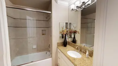 a bathroom with a sink and a tub and a mirror at 3 Bedroom 2 Bath Beachfront Home in Huntington Beach
