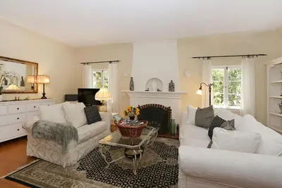 a living room with two white couches and a fireplace at Charming Pasadena English Cottage on Tree Lined Street in Pasadena