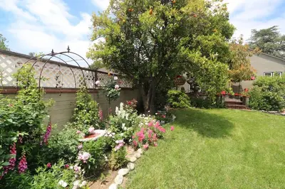 a garden with flowers and a tree in a yard at Charming Pasadena English Cottage on Tree Lined Street in Pasadena