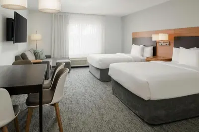 a hotel room with two beds and a desk at TownePlace Suites by Marriott Lancaster in Lancaster