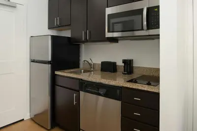 a kitchen with a sink and a microwave and a refrigerator at TownePlace Suites by Marriott Lancaster in Lancaster