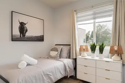 a bedroom with a bed and a picture of a cow on the wall at Angel & Rose * Hollywood DTLA in Los Angeles