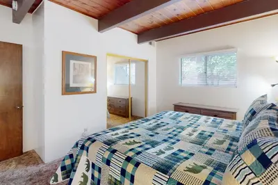 a bedroom with a bed and two windows at Rocky Pines in Twin Peaks