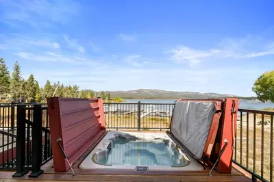 a hot tub on the deck of a house at 3 Cubs Lakefront - Stunning lakeside home with Hot Tub, Foosball, and Lake View in Big Bear Lake