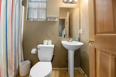 a bathroom with a toilet and a sink at Abe's Cool Cabin - Nice luxury home with a game room, hot tub, and pool table in Big Bear Lake