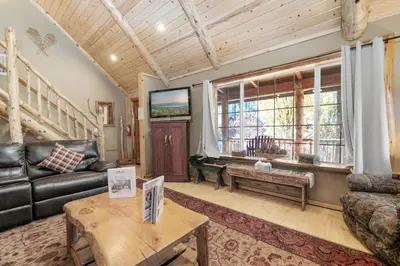 a living room with a couch and a table at Abe's Cool Cabin - Nice luxury home with a game room, hot tub, and pool table in Big Bear Lake