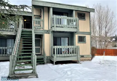 a house with a staircase in the snow at Bayview Condo - Condo is cozy and a great location for kayaking and paddle boarding! in Big Bear Lake