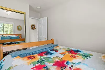 a bedroom with a bed with a flower blanket on it at Apples Delight -WALK TO THE LAKE! Enjoy the huge backyard with lovely forest views ! in Big Bear Lake