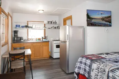 a kitchen with a refrigerator and a table in a room at Baby Bear - A delightful studio style property in the perfect central location! in Big Bear Lake