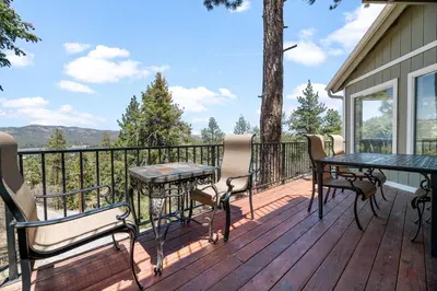 a deck with tables and chairs and a view of the mountains at BB Lake View Lodge - Gorgeous Lakeviews, Hot Tub, Jetted Tub, and Firepit! in Big Bear Lake