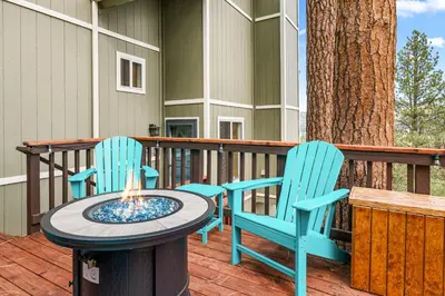 two blue chairs and a fire pit on a deck at BB Lake View Lodge - Gorgeous Lakeviews, Hot Tub, Jetted Tub, and Firepit! in Big Bear Lake