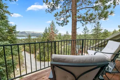 a balcony with a chair and a tree at BB Lake View Lodge - Gorgeous Lakeviews, Hot Tub, Jetted Tub, and Firepit! in Big Bear Lake