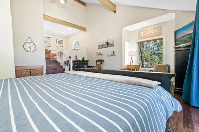a bedroom with a blue and white striped bed at BB Lake View Lodge - Gorgeous Lakeviews, Hot Tub, Jetted Tub, and Firepit! in Big Bear Lake