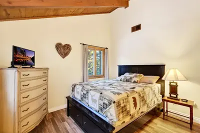 a bedroom with a bed and a dresser at Bear Claw Cabin - Perfect location with an amazing game room and hot tub! in Big Bear Lake