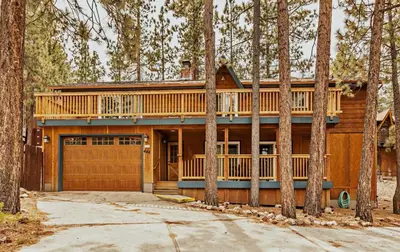 a log home with a deck and a garage at Bear Claw Cabin - Perfect location with an amazing game room and hot tub! in Big Bear Lake