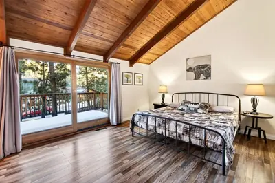 a bedroom with a bed and a balcony at Bear Claw Cabin - Perfect location with an amazing game room and hot tub! in Big Bear Lake