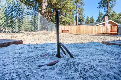a baseball bat in the sand in a batting cage at Bear Family Cabin - Stay together & play together! Foosball, billiards, hot tub, walk to lake! in Big Bear Lake