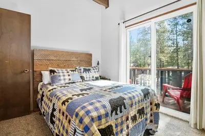 a bedroom with a bed and a sliding glass door at Bear PAC Hideout - Walk to Alpine Slide and only minuetes to The Village! Billiards and foosball! in Big Bear Lake