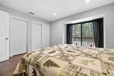 a bedroom with a bed and a window at Bear Retreat - Modern location within walking distance to Snow Summit with a private hot tub! in Big Bear Lake