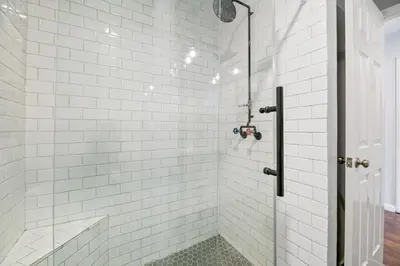 a white tiled shower with a glass door at Bear Retreat - Modern location within walking distance to Snow Summit with a private hot tub! in Big Bear Lake
