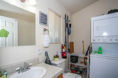 a bathroom with a sink and a mirror and a refrigerator at Ben's Cool Cabin - Phenomenal views and an ideal location close to all the local attractions! in Big Bear Lake