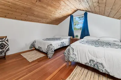 two beds in a room with a wooden ceiling at Big Bear Bungalow - Modern aesthetics meet mountain charm in this newly remodeled two-story home in Big Bear Lake
