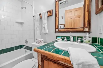a bathroom with a sink and a toilet and a tub at Blue Lagoon - Classic Lakefront Cabin with Pool Table! in Big Bear Lake