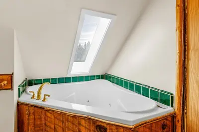 a bath tub in a bathroom with a window at Blue Lagoon - Classic Lakefront Cabin with Pool Table! in Big Bear Lake