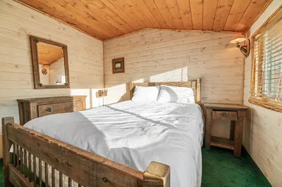 a bedroom with a bed in a wooden room at Blue Lagoon - Classic Lakefront Cabin with Pool Table! in Big Bear Lake