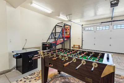 a foosball table in a room with a stair case at Boulder Bay Chalet Lakefront - Elegantly decorated with Hot Tub and Game Room! in Big Bear Lake