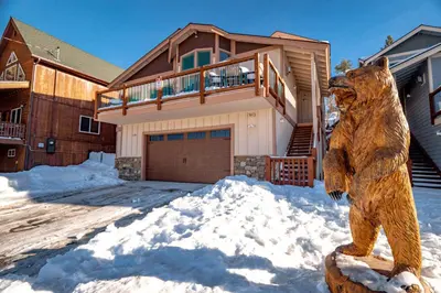 a bear statue in front of a house in the snow at Boulder Bay Chalet Lakefront - Elegantly decorated with Hot Tub and Game Room! in Big Bear Lake