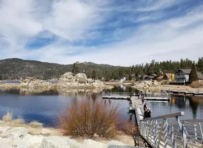 a bridge over a lake with people on it at Boulder Bay Lakefront Getaway - Across the street from the lake and Boulder Bay Park! in Big Bear Lake