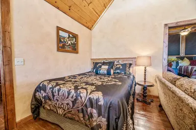 a bedroom with a bed and a couch at Boulder Bay Park Lakefront - Across the street from the lake and Boulder Bay Park! Hot tub! in Big Bear Lake