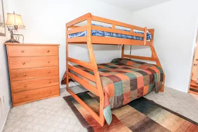a bedroom with a bunk bed and a dresser at Brown Bear's Den - Spacious condo within walking distance to all Big Bear has to offer! in Big Bear Lake
