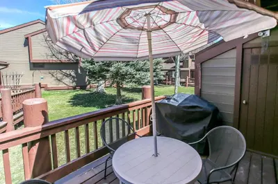 a patio table with an umbrella on a deck at Brown Bear's Den - Spacious condo within walking distance to all Big Bear has to offer! in Big Bear Lake
