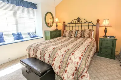 a bedroom with a bed and two night stands and a window at Brown Bear's Den - Spacious condo within walking distance to all Big Bear has to offer! in Big Bear Lake