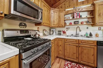 a kitchen with a stove and a sink at Catalina Retreat -Cozy mountain home in a tree filled neighborhood, plenty of games and a hot tub! in Big Bear Lake