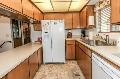 a kitchen with a white refrigerator and a sink at Chalet Georgia - Spacious and cozy home, conveniently close to the heart of Big Bear! in Big Bear Lake