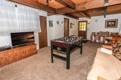 a living room with a pool table and a flat screen tv at Chalet Georgia - Spacious and cozy home, conveniently close to the heart of Big Bear! in Big Bear Lake