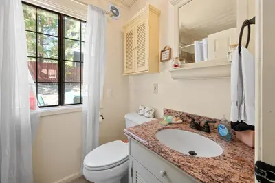 a bathroom with a sink and a toilet and a window at Chipmunk House - Magical Boulder Bay cottage within a picturesque setting! in Big Bear Lake