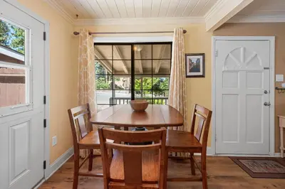 a dining room with a table and chairs and a window at Chipmunk House - Magical Boulder Bay cottage within a picturesque setting! in Big Bear Lake